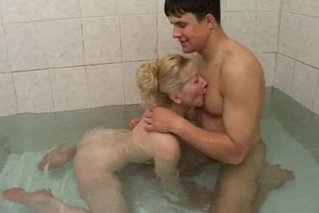 Skinny mature woman swims with a naked young male.